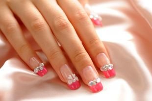 Маникюр с бантиками, ярко-розовый френч с бусинками и камнями на нарощенных ногтях
